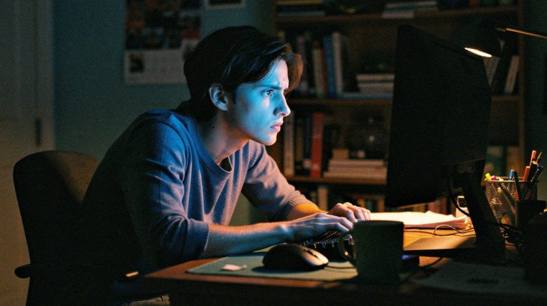 Person at a computer late at night, face illuminated by colorful screen glow